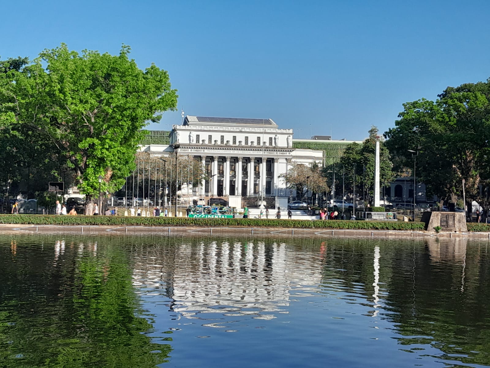 Image capturing the front of the Capitol and the Lagoon in the early morning. Plenty of people jog around the park.