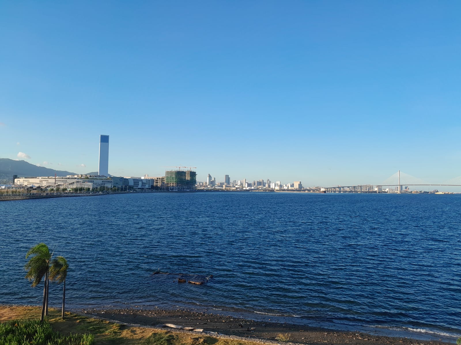A view of Cebu City from the NUSTAR Resort Cebu. On the right you can see the Cebu-Cordova Link Expressway and on the left is the SM Seaside City Cebu. 80% of the picture is composed of the sea and the sky. I was being present in the moment, feeling the wind banging against me.