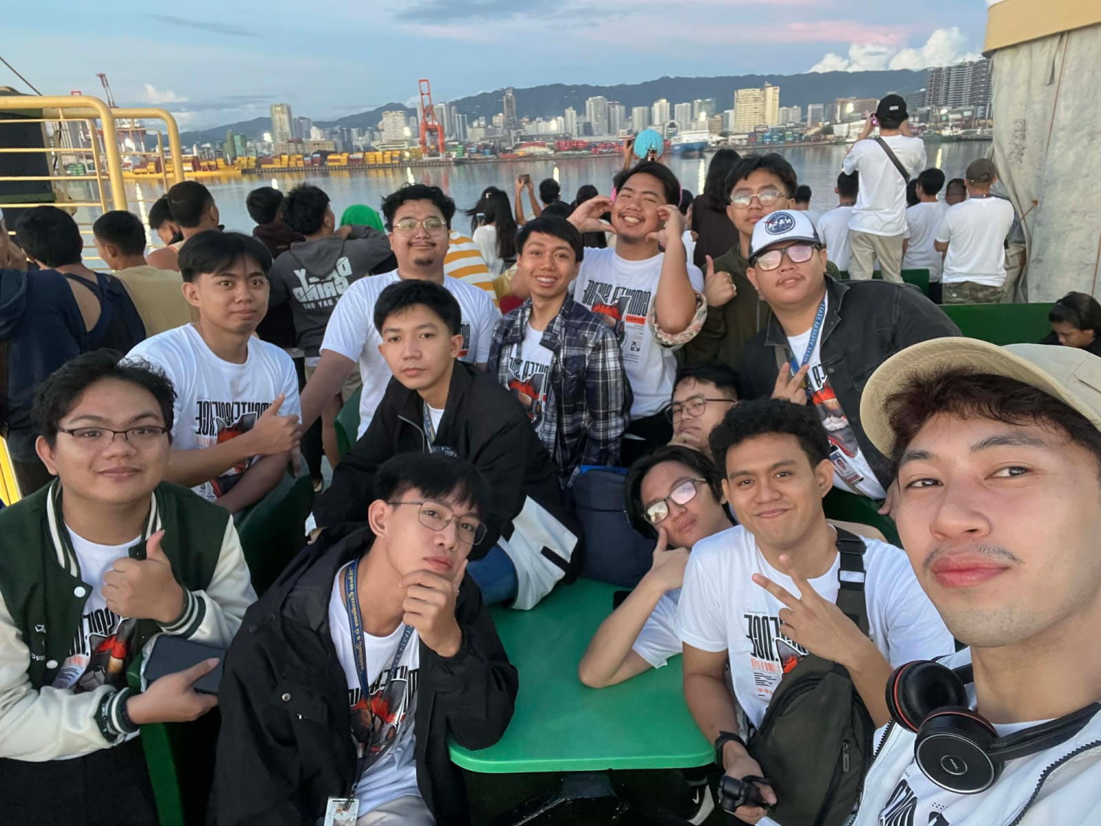 A picture with my classmates when we arrived in Cebu for the first time last November 18, 2025. I stand at the middle back, wearing a black and grey grid pattern jacket. We went outside of the deck before 6 AM just to see the skyline and the sun rising majestically.
